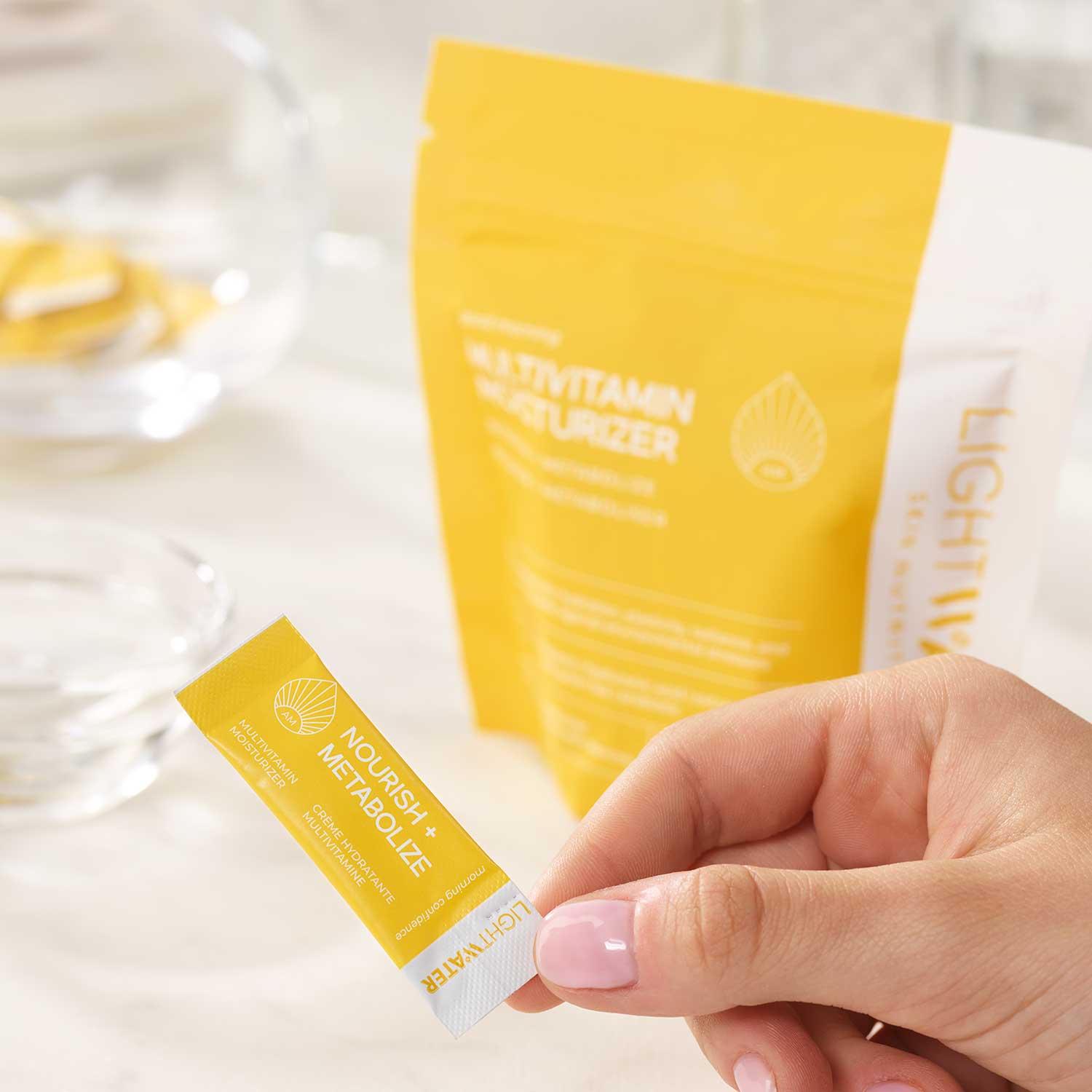 LightWater AM Multivitamin Moisturizer packaging pouch and one of its 28 daily doses in hand.